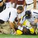 Michigan trainers tend to senior quarterback Denard Robinson after he injured his back during the second half of the Cowboy Classic against Alabama at Cowboy Stadium in Arlington, Texas on Saturday. Melanie Maxwell I AnnArbor.com